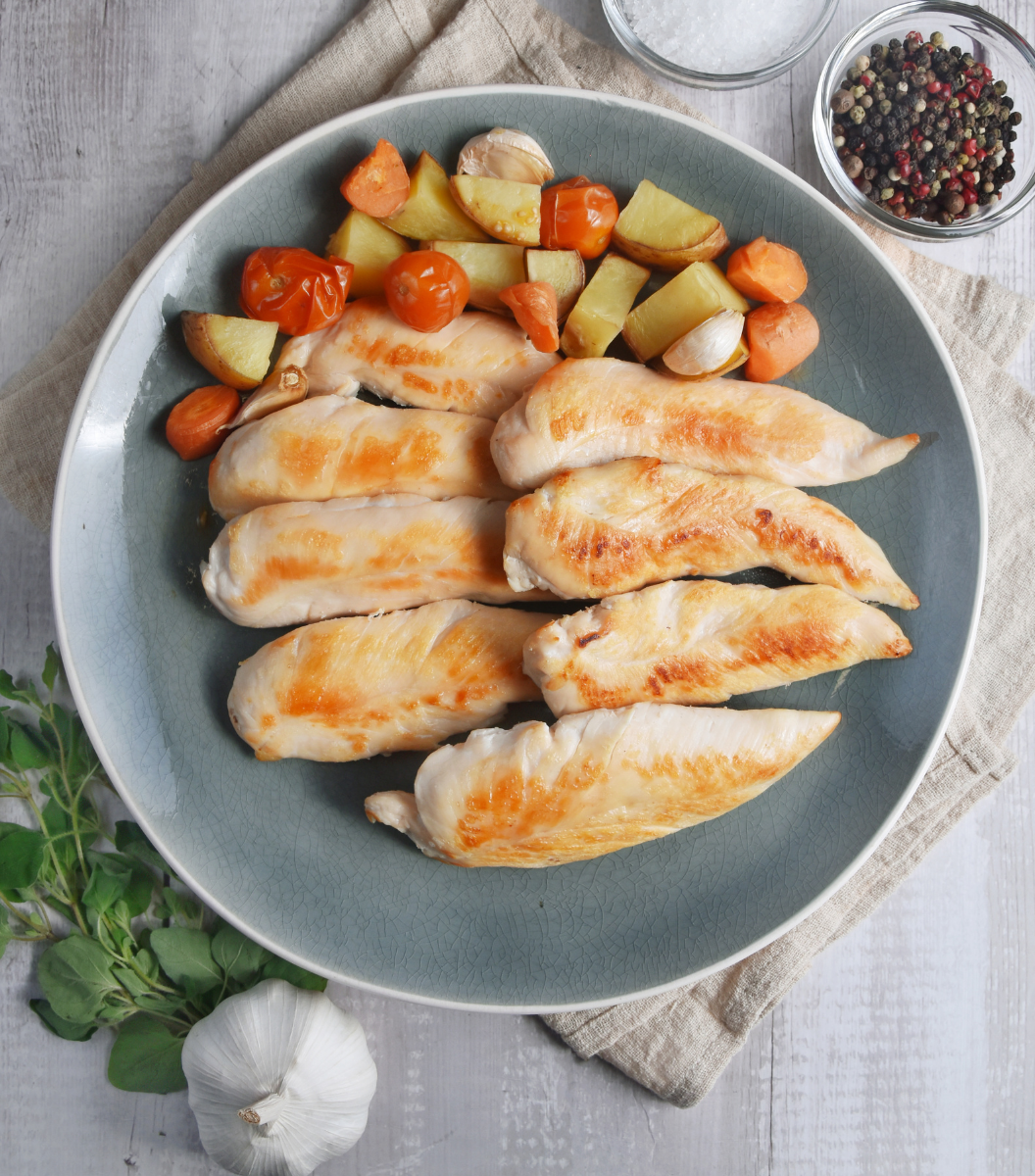 Deliciously cooked Fox River Australian Free-Range Chicken Tenderloin with tomato, carrot and potato on a blue plate
