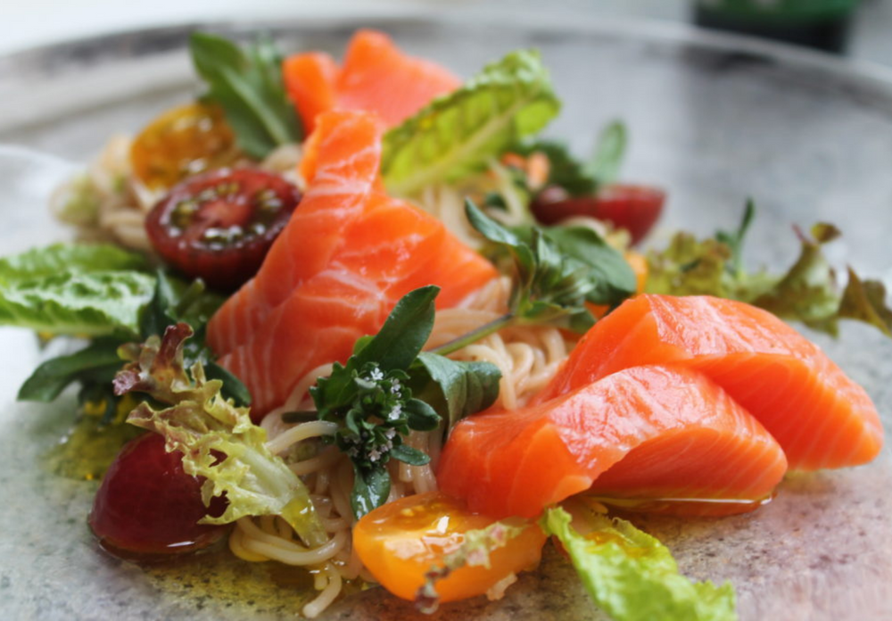 Fresh Salmon and vege with olive oil dressing on a plate