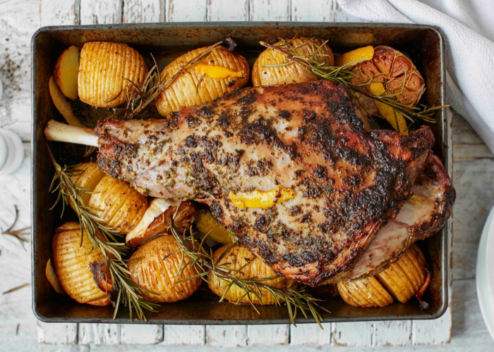 Deliciously Roasted Bone In Leg of Lamb with grilled potatoes and finely chopped rosemary leave