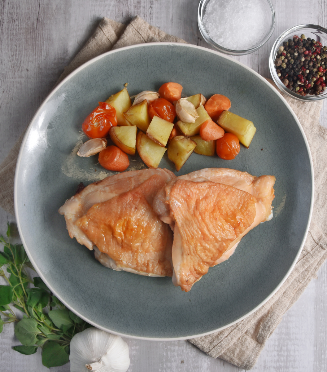 Deliciously cooked Fox River Australian Free-Range Chicken Thigh with tomato, carrot and potato on a blue round plate